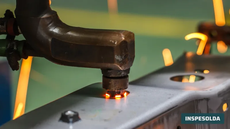 Eletrodo de cobre de uma máquina de solda por resistência pressionando uma peça de chapa, com o ponto incandescente e faíscas