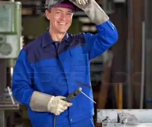 Profissional soldador sorrindo com EPI em ambiente industrial.