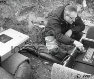 Técnico prepara equipamento para ensaio de radiografia industrial.