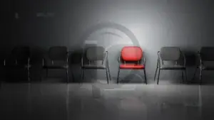 Fornecedores Industriais 3 Cadeira vermelha destacada em uma fileira de cadeiras pretas.