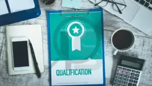 Prancheta com símbolo de medalha e a palavra "Qualification" sobre uma mesa.