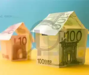 Casas feitas de notas de dinheiro, representando o custo de materiais de baixa qualidade.