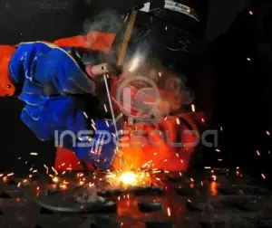 Manutenção de soldagem 1 Soldador realizando manutenção com arco elétrico ativo.