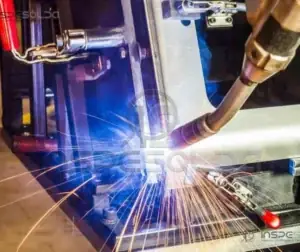Braço de máquina de corte a plasma cortando uma chapa metálica, com faíscas.