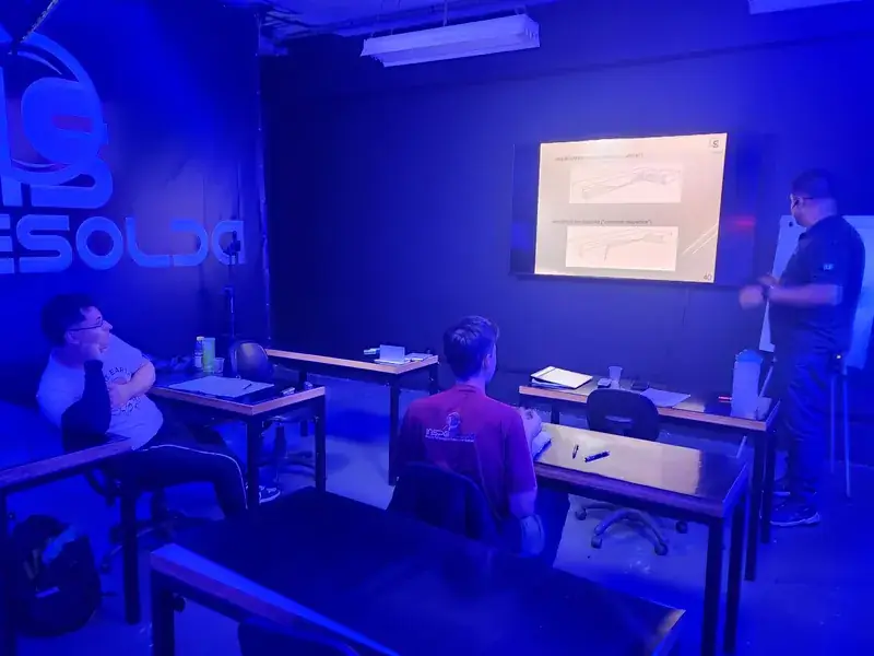 Turma em sala de aula durante treinamento teórico de soldagem.