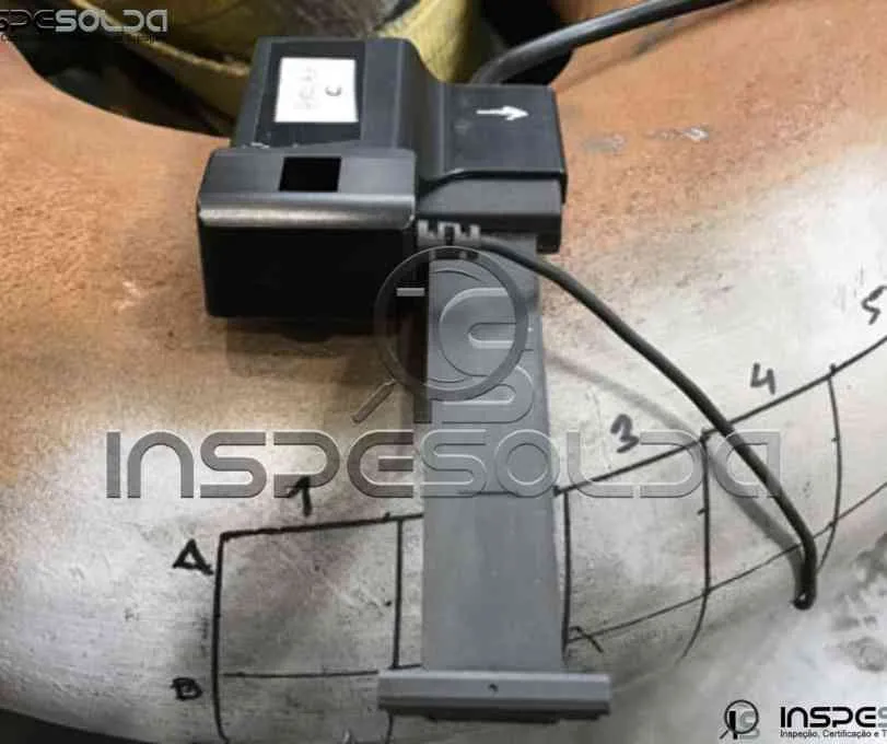 Equipamento de correntes parasitas inspeciona superfície metálica.