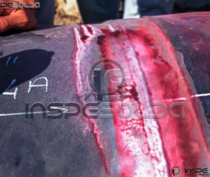 Indicação de trinca revelada por líquido penetrante vermelho.