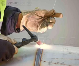 Instrutor orientando soldador durante treinamento prático no processo TIG.