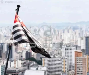 Vista da cidade de São Paulo com bandeira do estado em destaque.