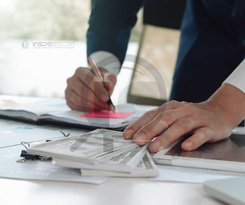 Profissionais analisando documentos de certificação de aprovação.