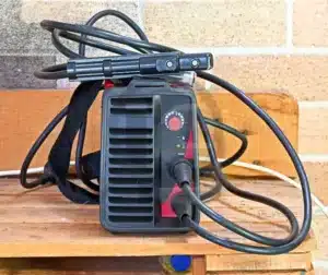 Máquina de solda com cabos e acessórios para processos de produção.