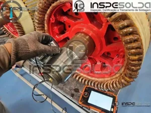 Inspeção por ultrassom industrial sendo feita em eixo com equipamento especializado da InspeSolda.